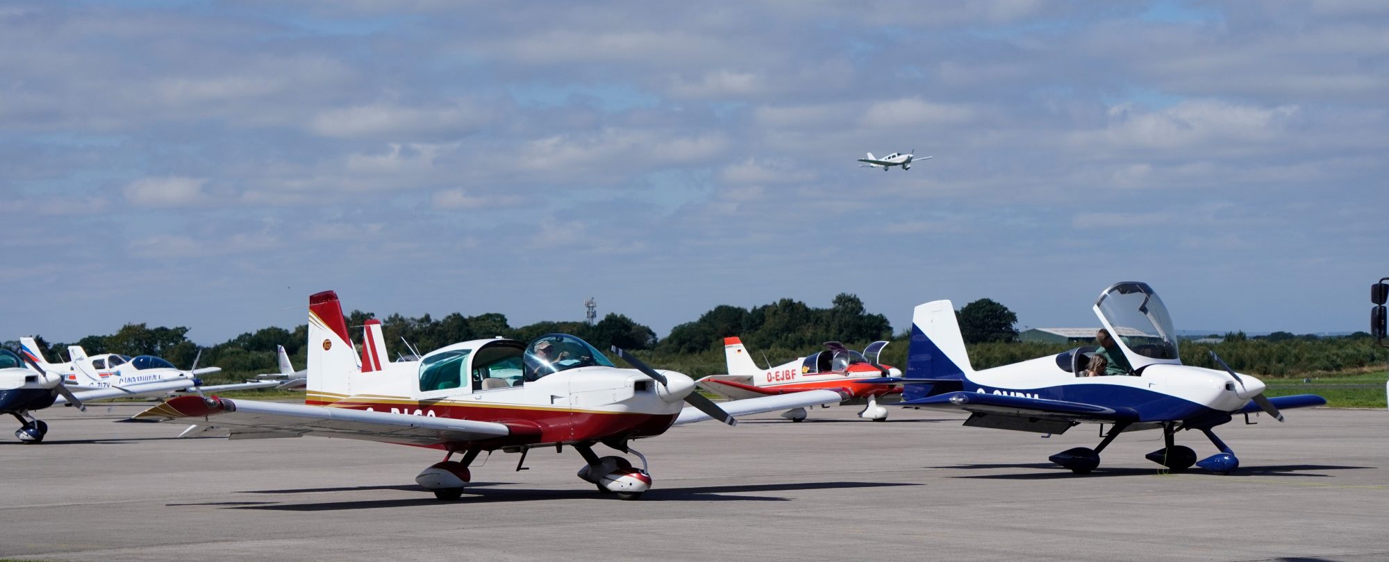 Planes with plane in sky in the background